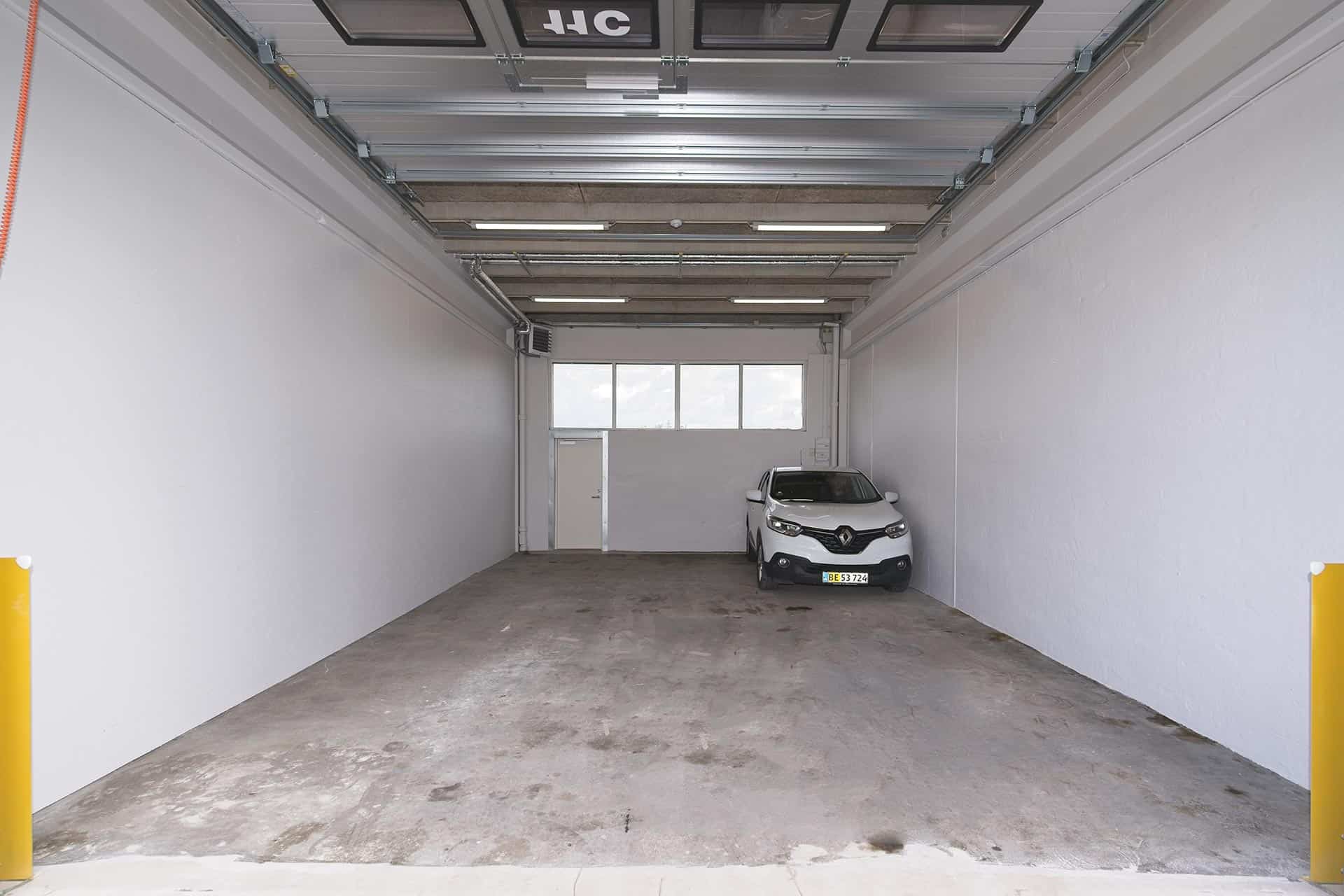 Hvid bil parkeret i lagerlokale